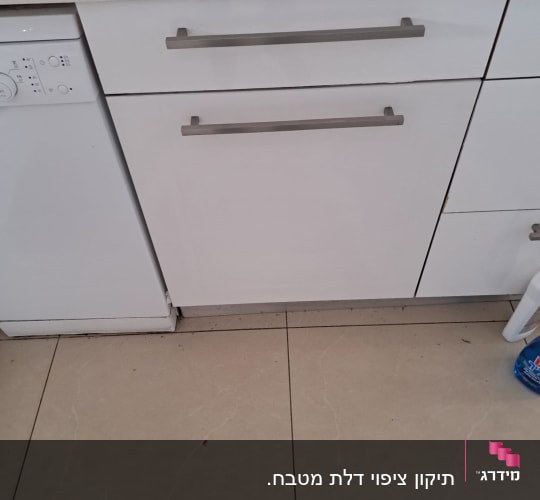 כיור מטבח עם ארונות לבנים ומדיח כלים